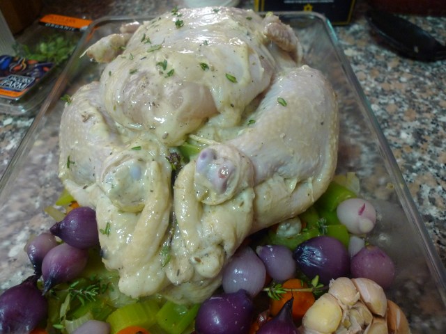place trussed chicken in an oven roast pan with rest of the vegetables lining the bottom on the pan