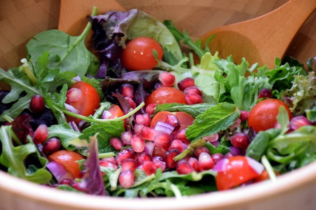 toss salad leaves, mint, cherry tomatoes, red onion and pomegranate seeds